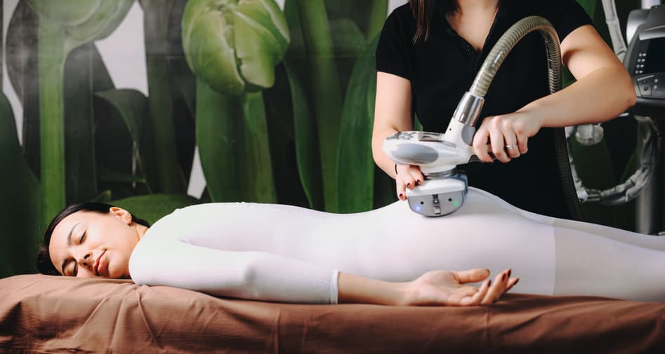 Caucasian woman lying on the couch in a spa center having a lpg procedure over her special white suit Caucasian woman lying on the couch in a spa center having a lpg procedure over her special white suit